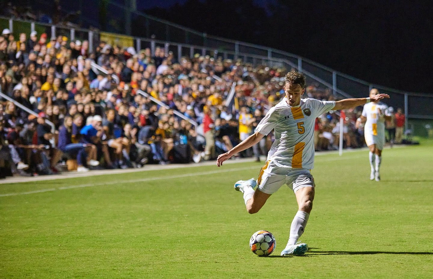 College athletic scholarship student kicking ball playing soccer in college who was recruited